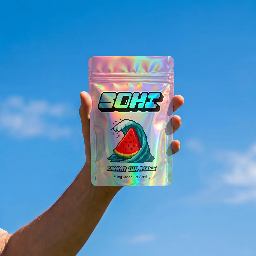 Hand holding a SOHI gummy package against a blue sky