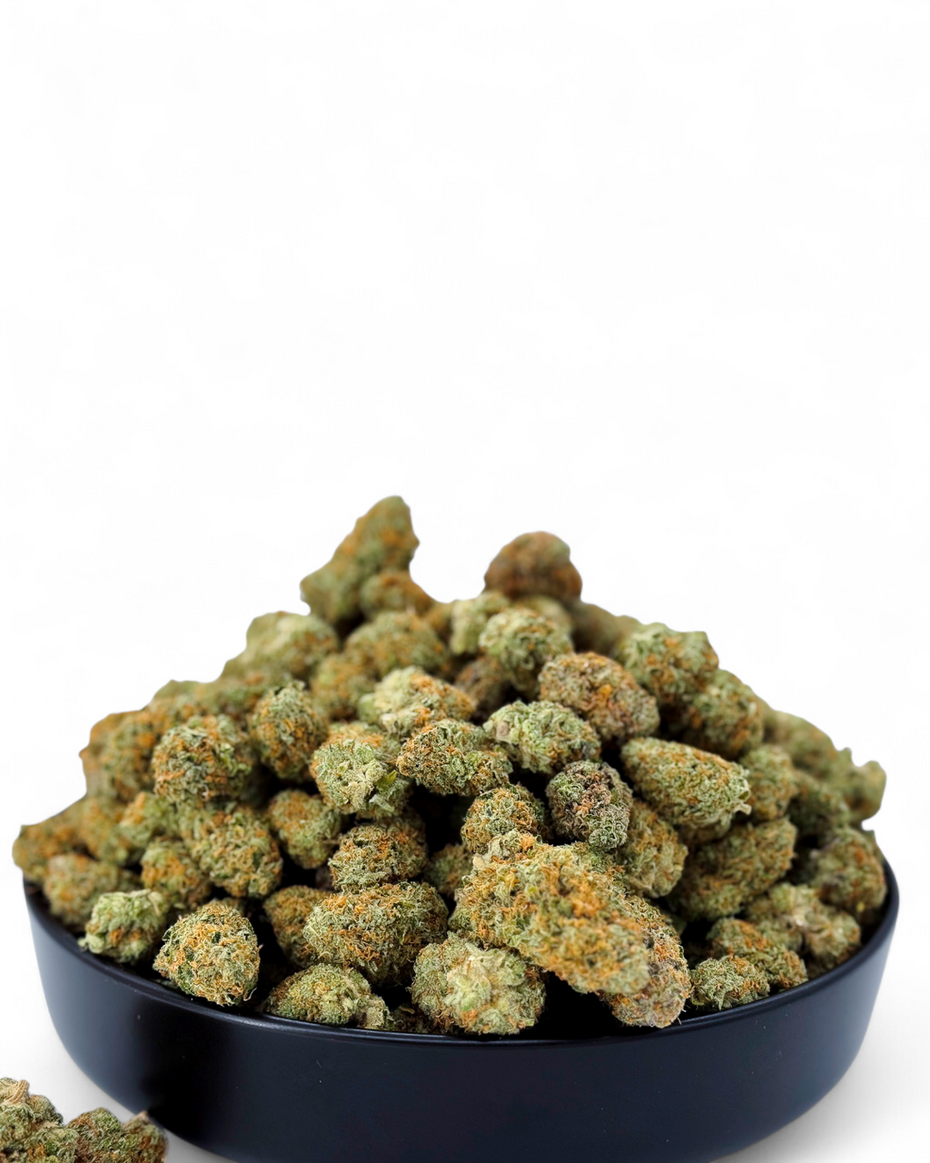 Bowl of green cannabis buds on a white background