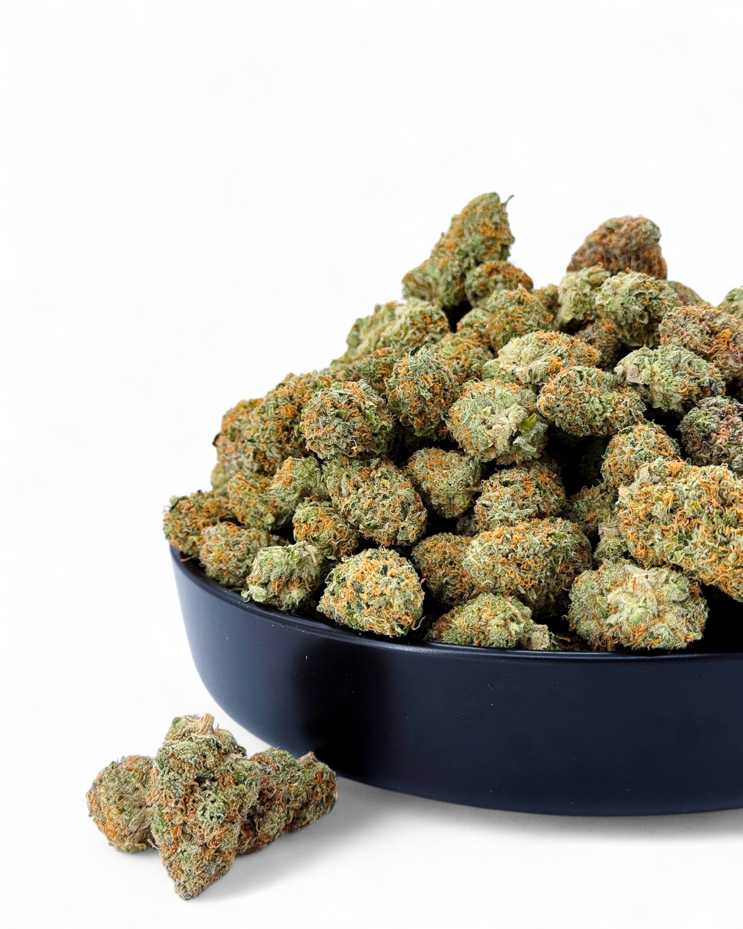 Bowl filled with cannabis buds on a white background