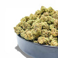 Bowl filled with green cannabis buds on a white background showing wholesale THCa flower from Dr. Wonderstone