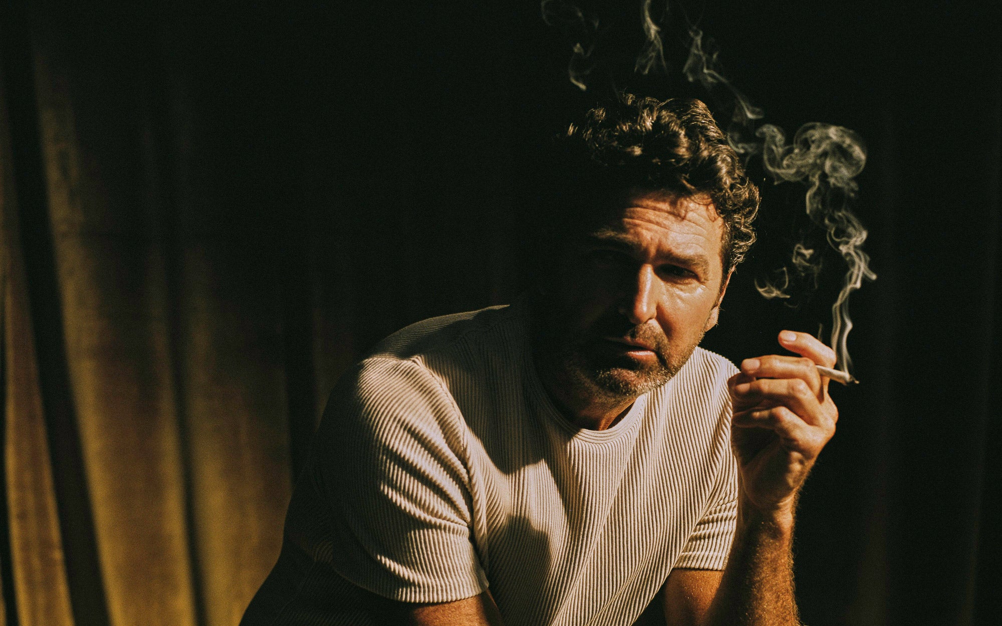 Man smoking a cigarette in a dimly lit room