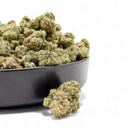 Bowl filled with cannabis buds on a white background