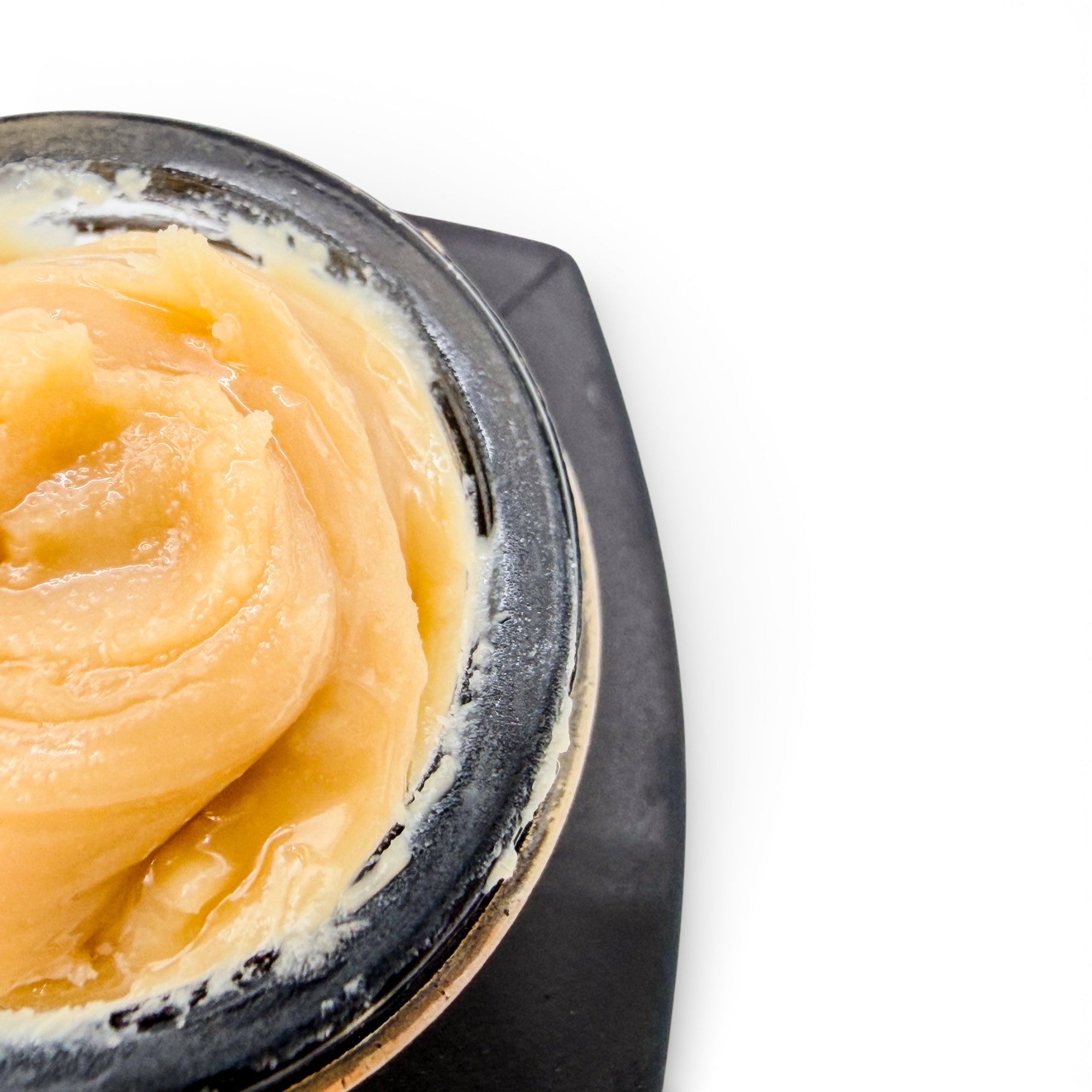 Close-up of a container with a yellowish substance on a white background