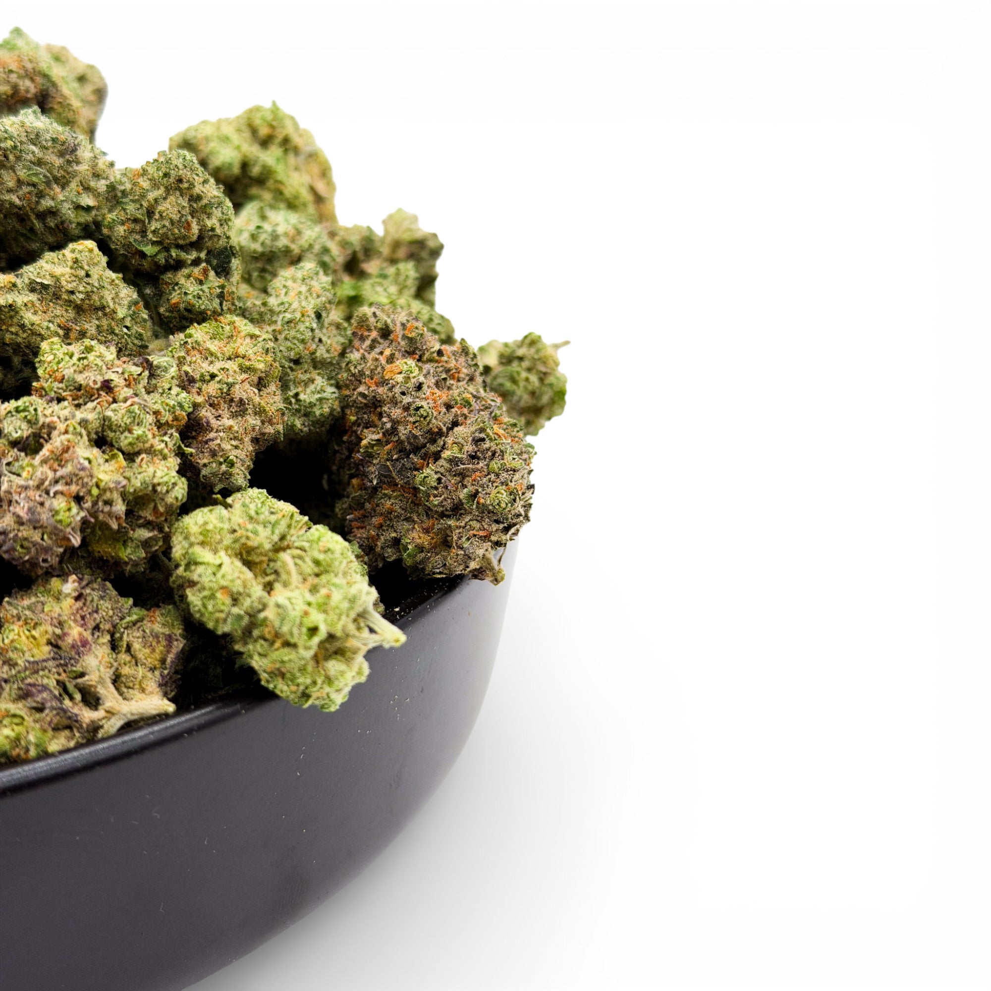 Bowl filled with cannabis buds on a white background