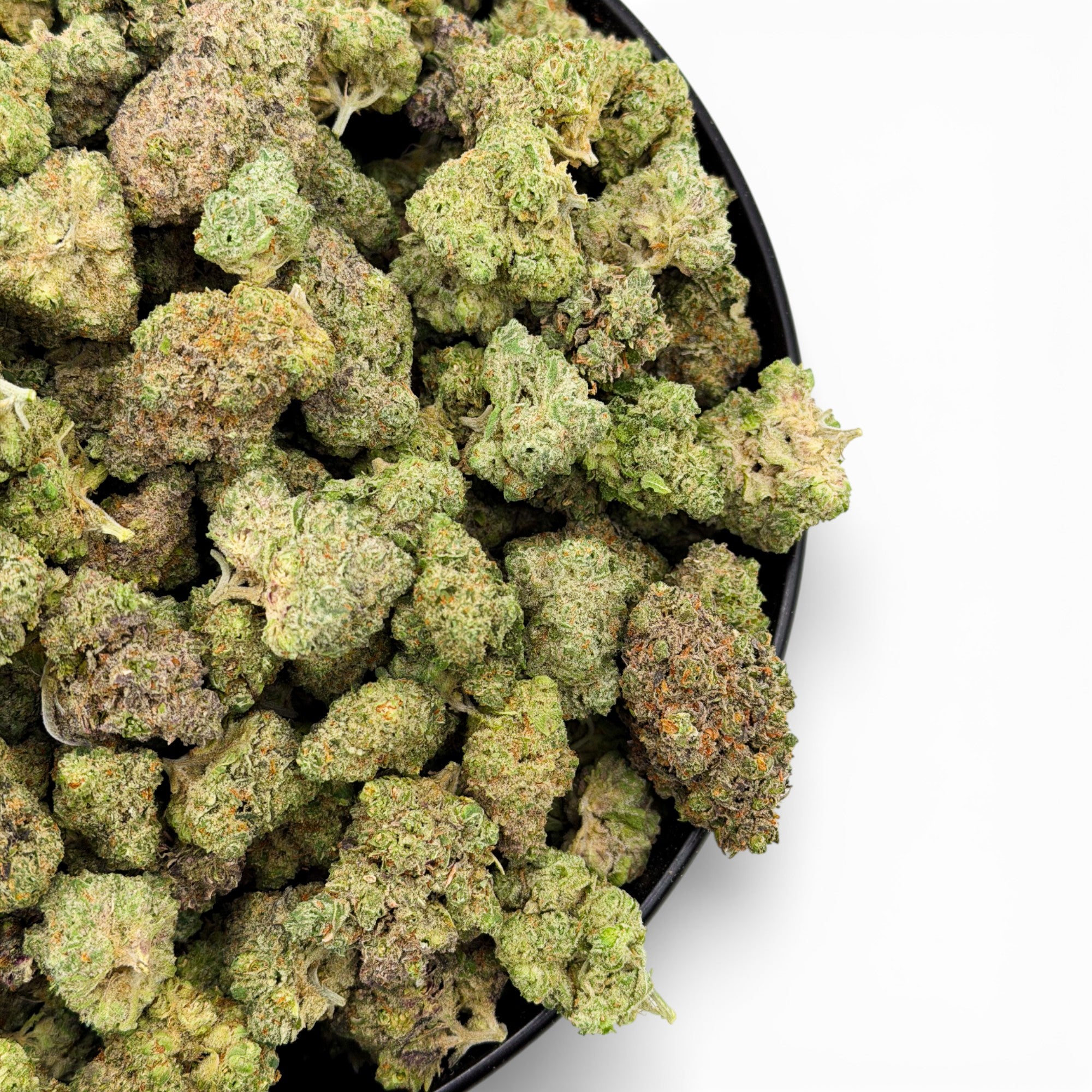 Close-up of green cannabis buds in a black container on a white background