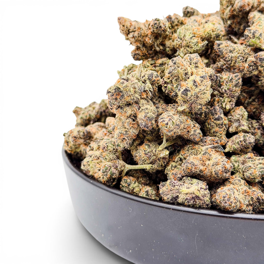 Dr. Wonderstone Premium THCa Flower buds in a dark bowl, featuring green, purple, and orange hues.