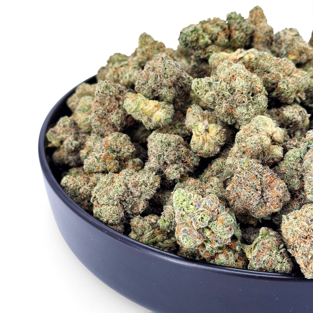 Dr. Wonderstone Banana Zkittlez THCa flower featuring dense, frosted green buds with orange hairs in a black bowl.