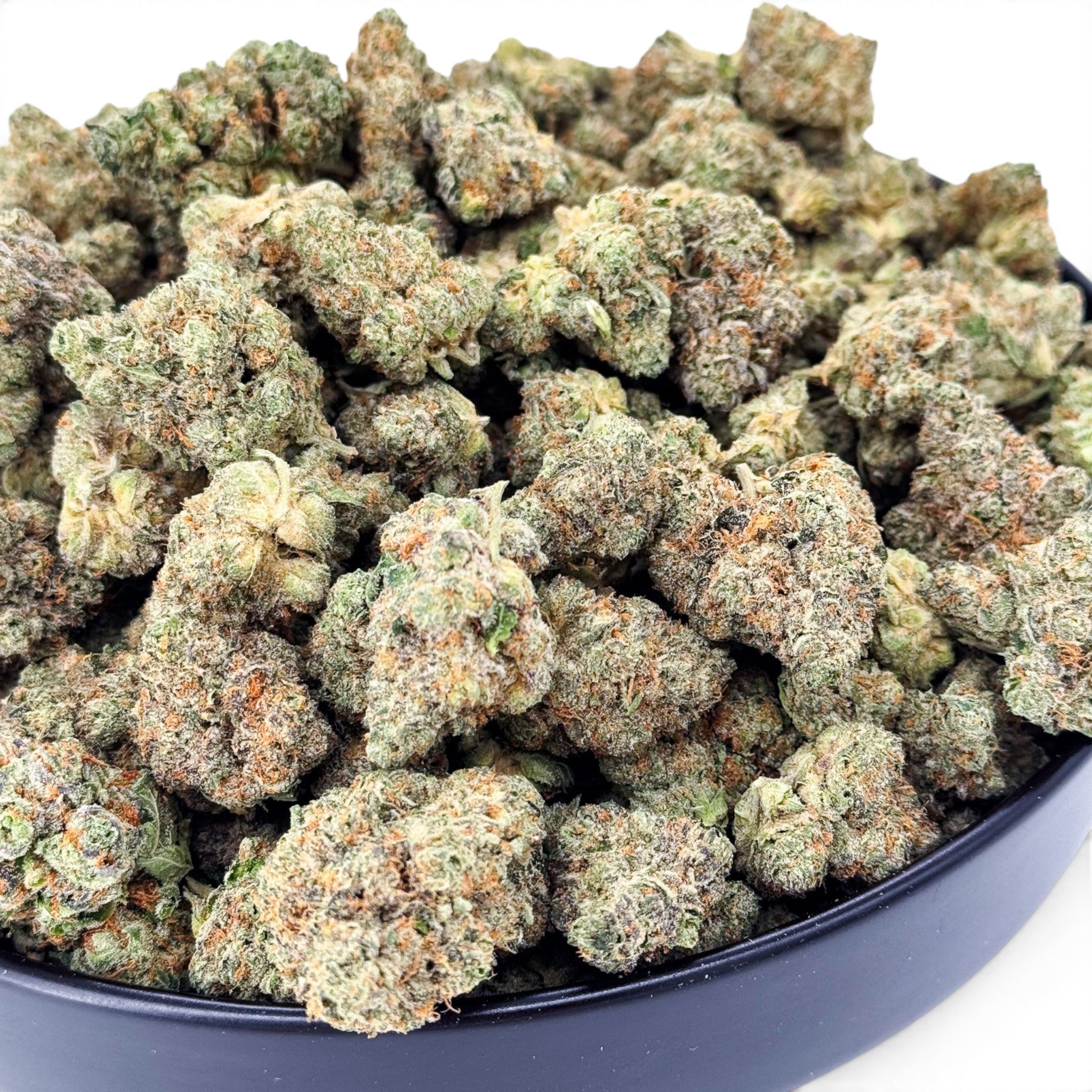 Dr. Wonderstone Banana Zkittlez THCa flower featuring dense, frosted green buds with orange pistils in a black bowl.