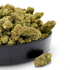 Dr. Wonderstone Bubble Gum premium indoor THCa flower buds with dense structure and orange pistils in a black bowl.