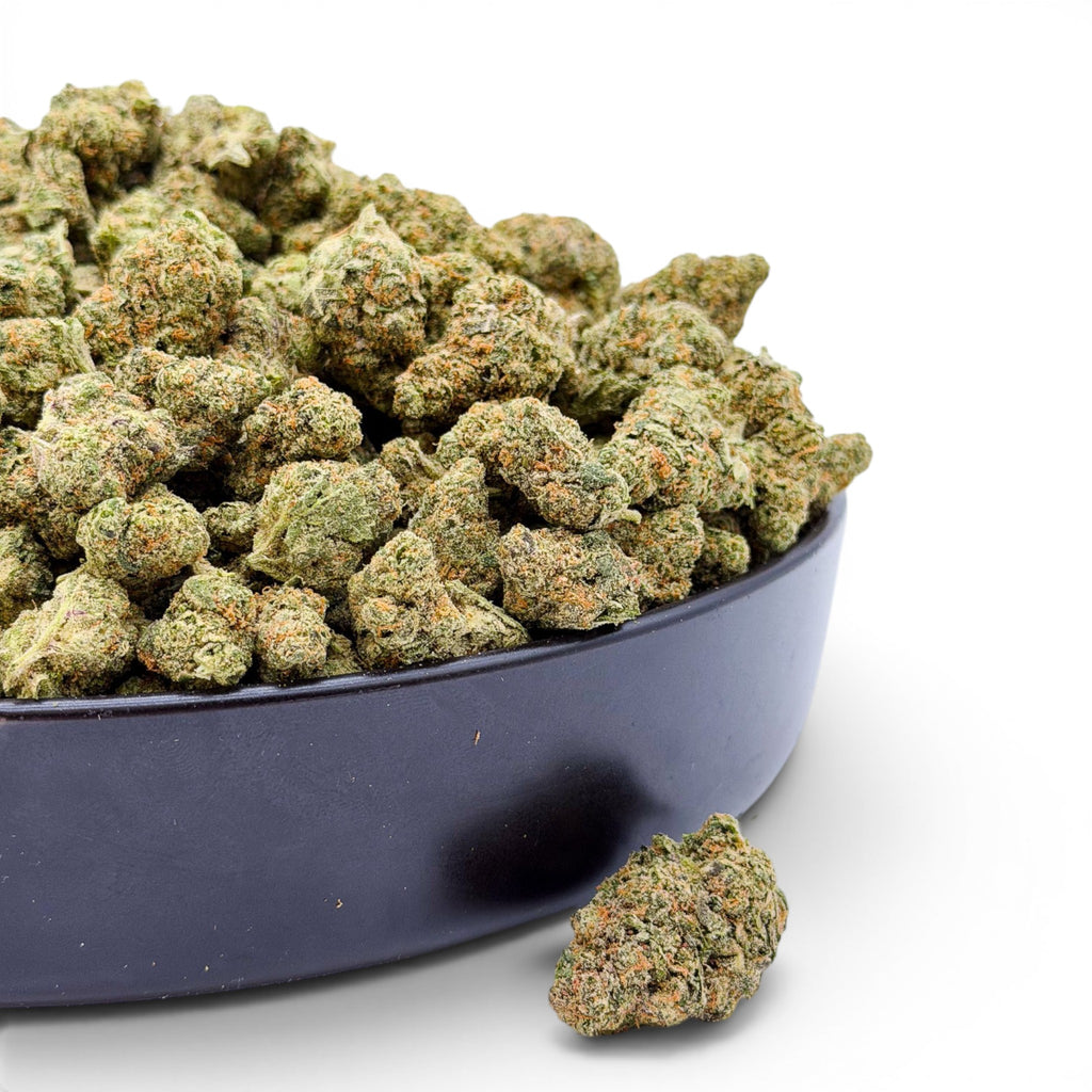 Dr. Wonderstone Elektra Ice THCa flower buds in a black bowl, featuring dense green nugs with orange pistils.