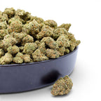 Dr. Wonderstone Elektra Ice THCa flower buds in a black bowl, featuring dense green nugs with orange pistils.