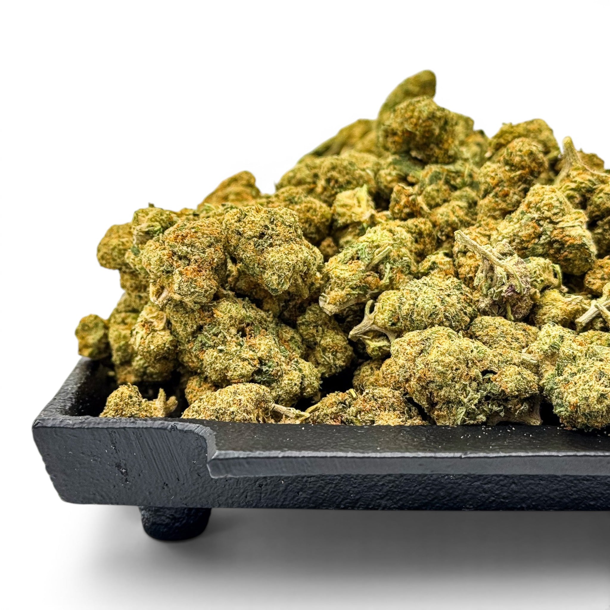 Dr. Wonderstone Green Crack THCa flower buds piled on a black tray, featuring dense green nugs with orange pistils.