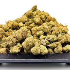 Dr. Wonderstone Green Crack THCa flower buds featuring dense, light green nugs with orange pistils on a black tray.