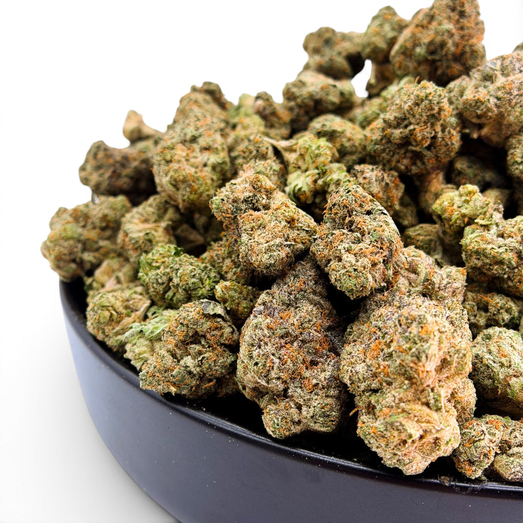 Dr. Wonderstone Ice Cream Pie THCa flower buds in a black bowl featuring dense green nugs with orange pistils