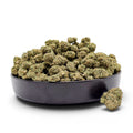 Dr. Wonderstone Lemon Cherry Gelato THCa flower in a black bowl, featuring dense, frosted green buds with amber pistils. Value Indoor grown Wholesale THCa Flower.