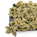 Dr. Wonderstone London Pound Cake THCa flower buds with frosty green texture and orange pistils on a black tray.