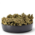 Dr. Wonderstone London Pound Cake THCa flower buds piled in a black bowl against a white background.