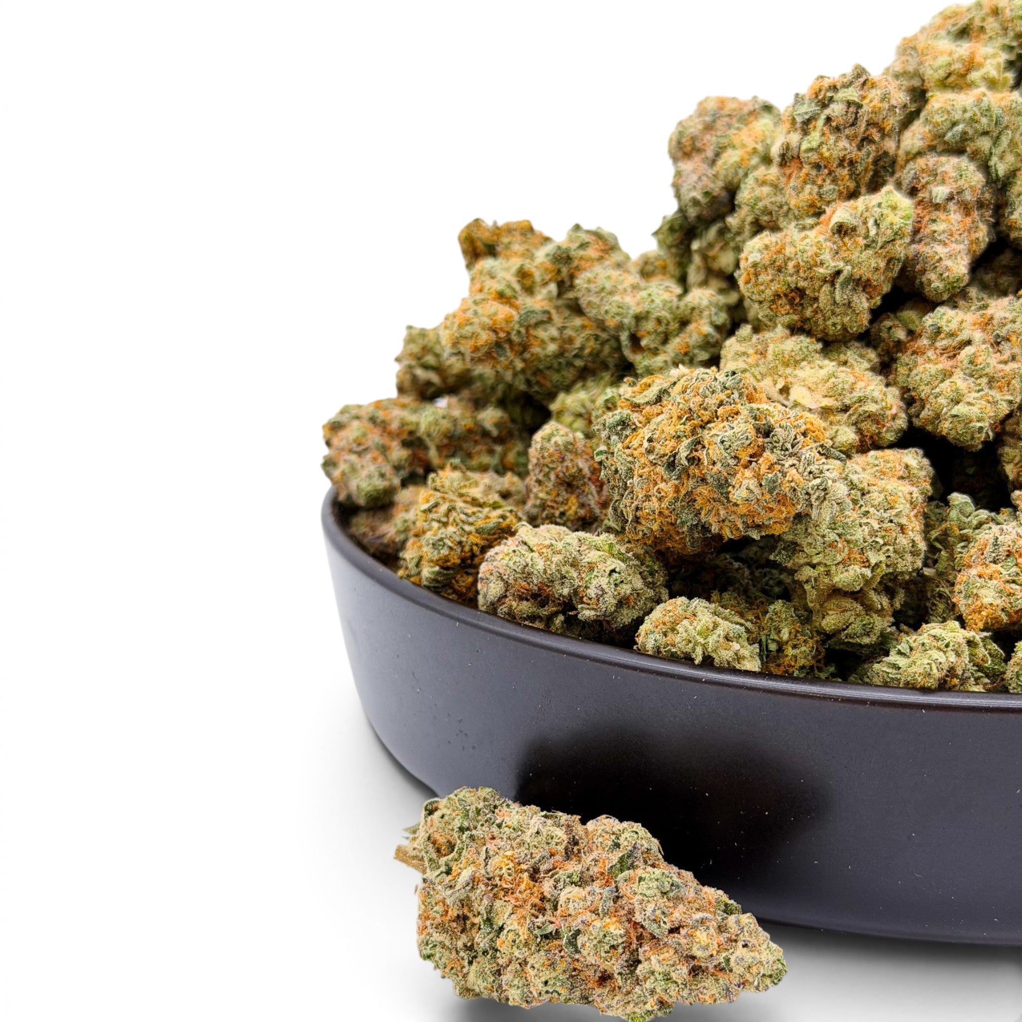 Dr. Wonderstone Orange Blueberry Muffin THCa flower buds in a black bowl, showing dense green nugs with orange pistils.