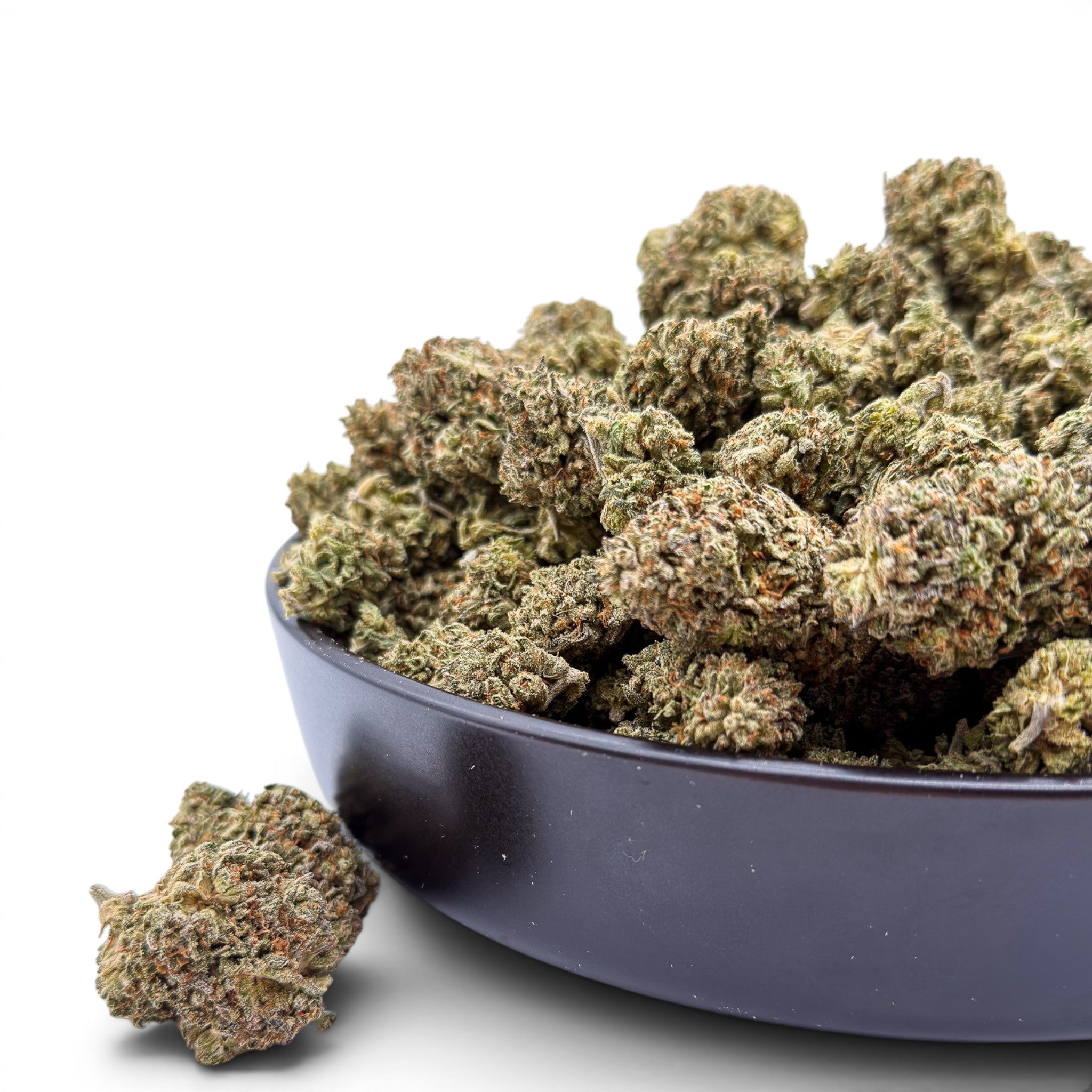 Dr. Wonderstone Oreoz THCa flower buds in a black bowl, featuring dense green nugs with orange pistils.