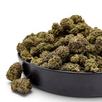 Dr. Wonderstone Oreoz THCa flower in a black bowl, featuring dense, trichome-rich green buds with earthy tones.