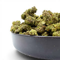 Dr. Wonderstone Pineapple hybrid THCa flower buds with dense green structure and trichomes in a black bowl.