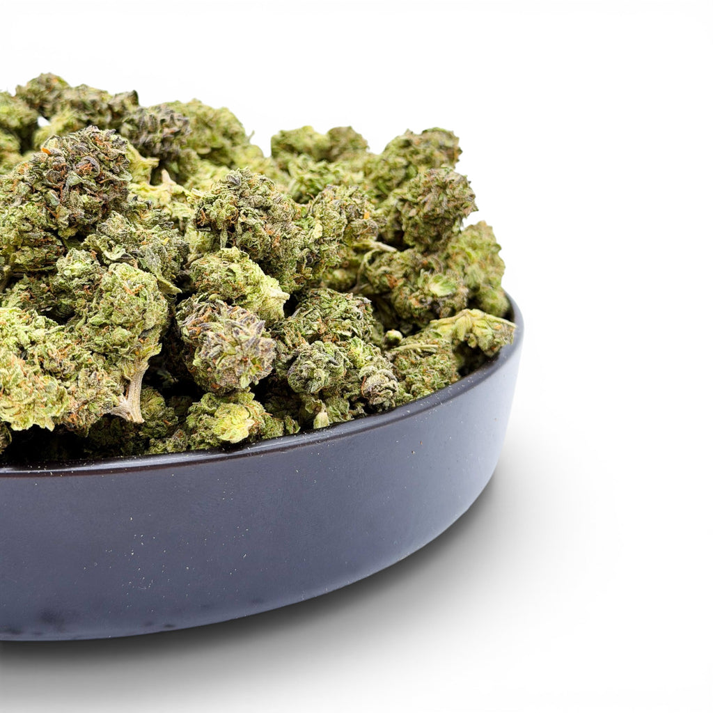 Dr. Wonderstone Pineapple hybrid THCa flower in a black bowl, featuring dense, trichome-rich bright green buds.