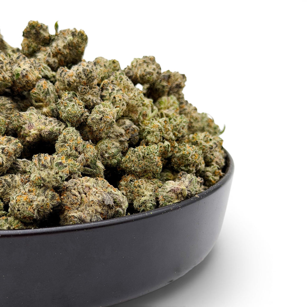 Dr. Wonderstone Secret Cookies THCa flower buds in a black bowl, featuring dense green nugs with orange pistils.