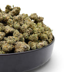 Dr. Wonderstone Secret Cookies THCa flower buds in a black bowl, featuring dense green nugs with orange pistils.