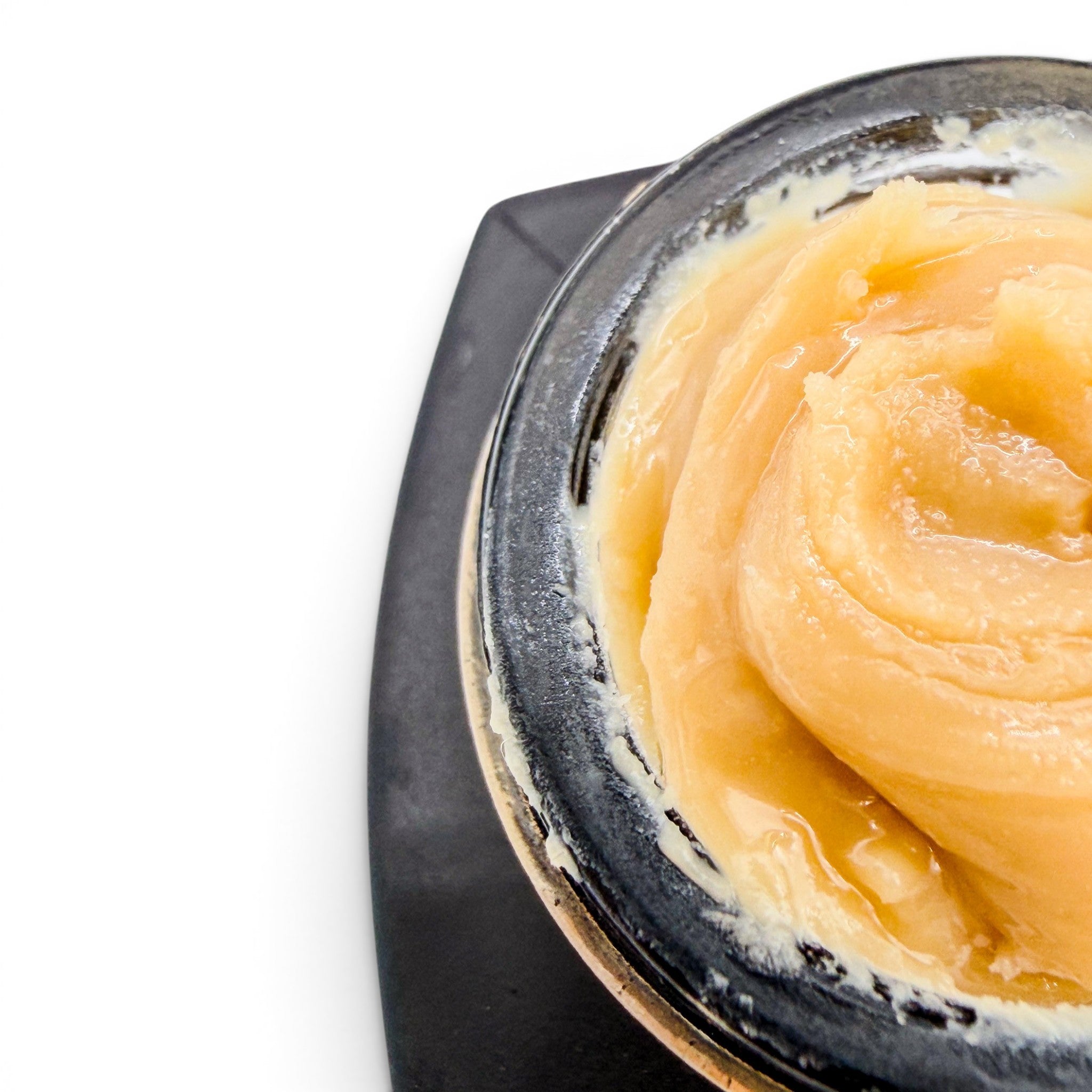 Dr. Wonderstone THCa premium live rosin concentrate with a smooth, buttery, golden texture inside a black jar.