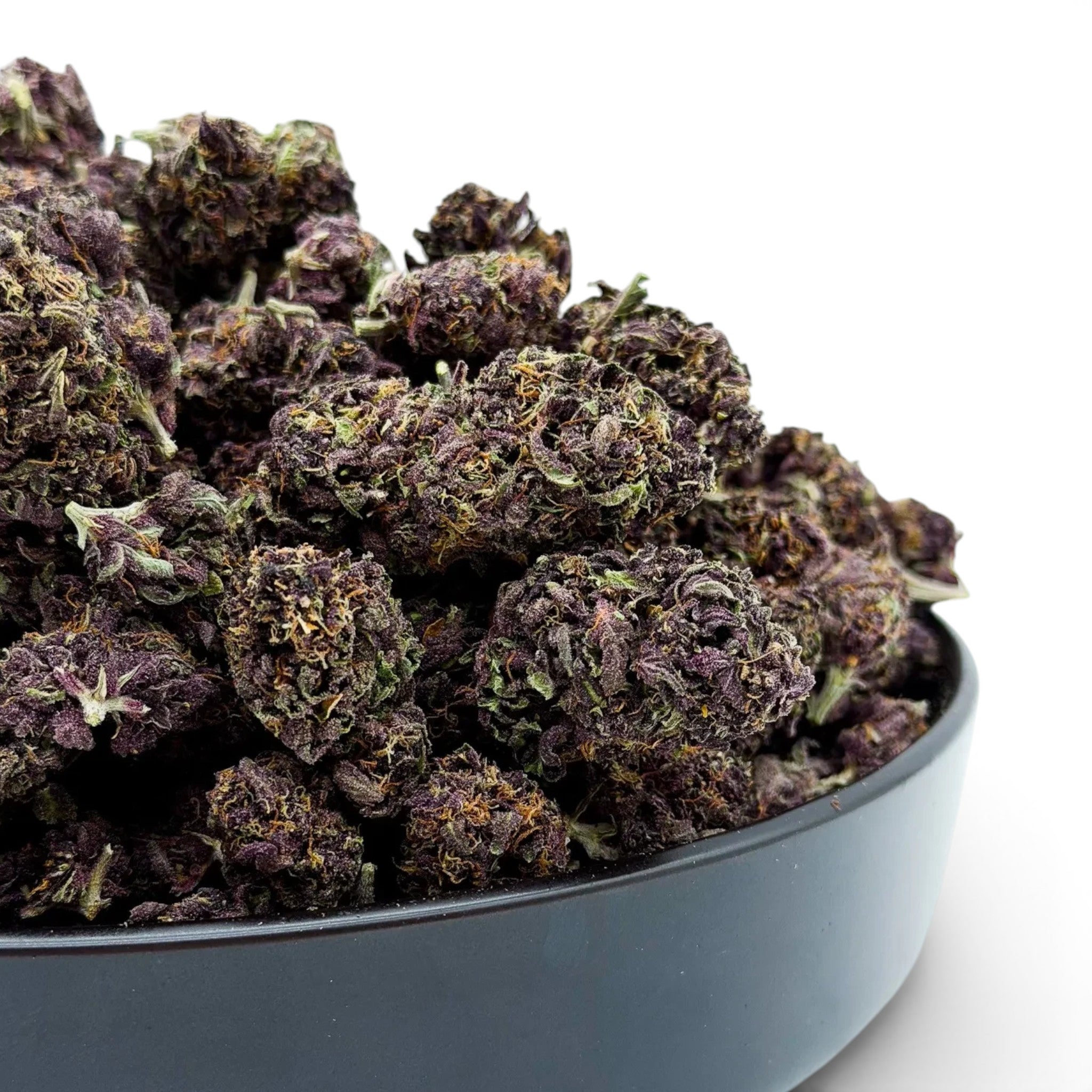 Dr. Wonderstone Tropical Cookies THCa flower featuring dense, dark purple buds with orange pistils in a black bowl.
