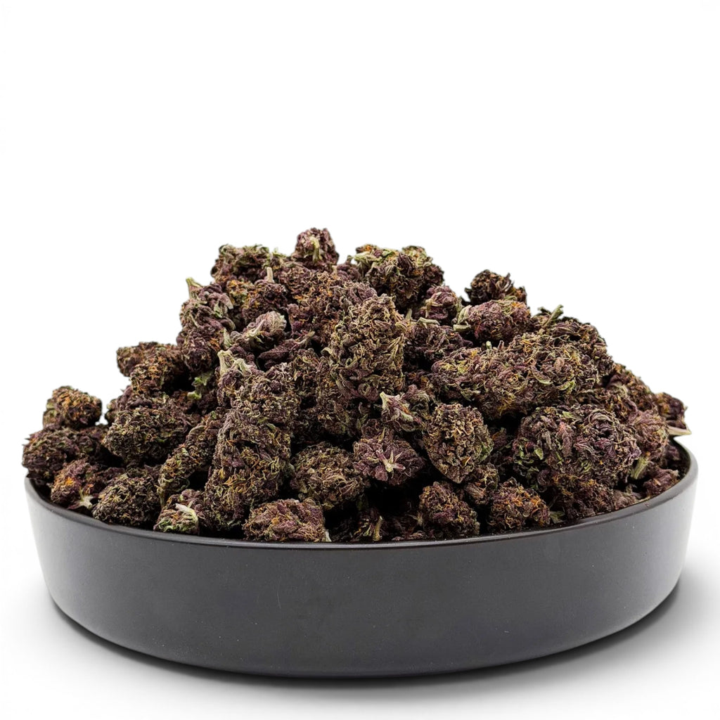 Dr. Wonderstone Tropical Cookies THCa flower in a black bowl, featuring dense, dark purple buds with visible trichomes.