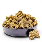Dr. Wonderstone Wedding Cake THCa flower buds in a black bowl, featuring crystal-dusted green and earthy tones.